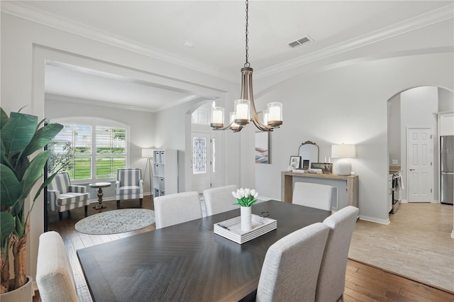 405 Courtlea Park Dr, Winter Garden, FL 34787 - dining space featuring arched walkways, a chandelier, ornamental molding, light wood-style flooring, and baseboards