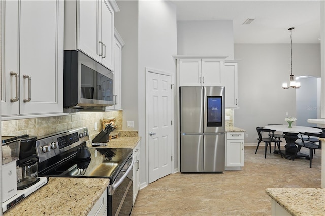 405 Courtlea Park Dr, Winter Garden, FL 34787 - kitchen with appliances with stainless steel finishes, tasteful backsplash, white cabinets, a chandelier, and light stone counters