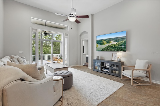 405 Courtlea Park Dr, Winter Garden, FL 34787 - living area featuring arched walkways, a towering ceiling, a ceiling fan, and baseboards