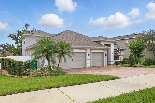 405 Courtlea Park Dr, Winter Garden, FL 34787 - mediterranean / spanish home featuring stucco siding, an attached garage, decorative driveway, and a shingled roof