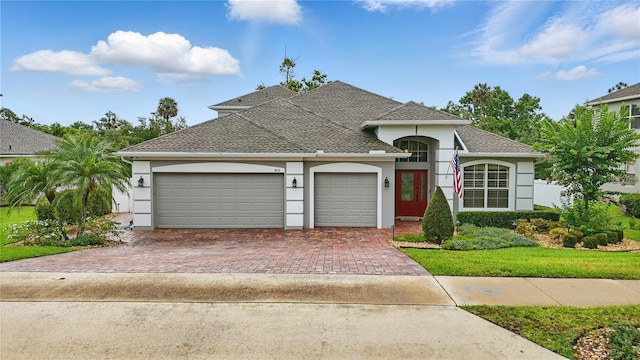 405 Courtlea Park Dr, Winter Garden, FL 34787 - view of front of property with stucco siding, an attached garage, decorative driveway, and roof with shingles