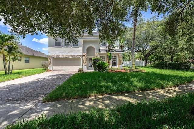 809 Kazaros Cir, Ocoee, FL 34761 - view of front of property featuring a garage, stone siding, stucco siding, decorative driveway, and a front yard