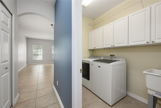 809 Kazaros Cir, Ocoee, FL 34761 - laundry room with separate washer and dryer, cabinet space, light tile patterned floors, and baseboards