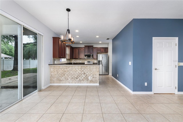809 Kazaros Cir, Ocoee, FL 34761 - kitchen featuring appliances with stainless steel finishes, dark countertops, dark brown cabinetry, decorative backsplash, and a peninsula