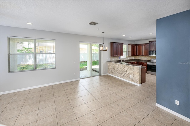 809 Kazaros Cir, Ocoee, FL 34761 - kitchen featuring appliances with stainless steel finishes, a peninsula, a textured ceiling, a chandelier, and light tile patterned floors