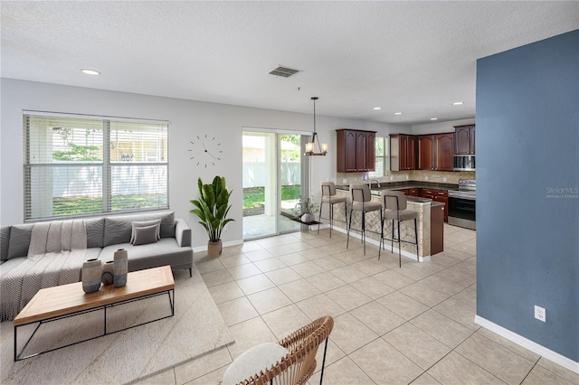 809 Kazaros Cir, Ocoee, FL 34761 - living area featuring light tile patterned floors, a chandelier, a textured ceiling, baseboards, and recessed lighting