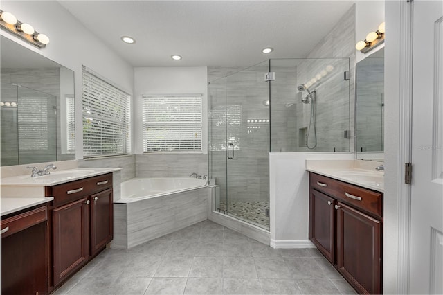 809 Kazaros Cir, Ocoee, FL 34761 - full bathroom featuring two vanities, tile patterned floors, a stall shower, a garden tub, and recessed lighting