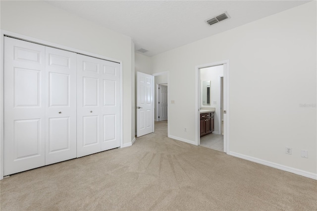 809 Kazaros Cir, Ocoee, FL 34761 - unfurnished bedroom with light colored carpet, a closet, baseboards, and connected bathroom