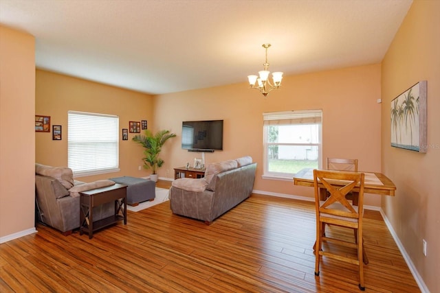 4642 Waterside Pointe Cir, Orlando, FL 32829 - living area featuring wood finished floors, a chandelier, and baseboards