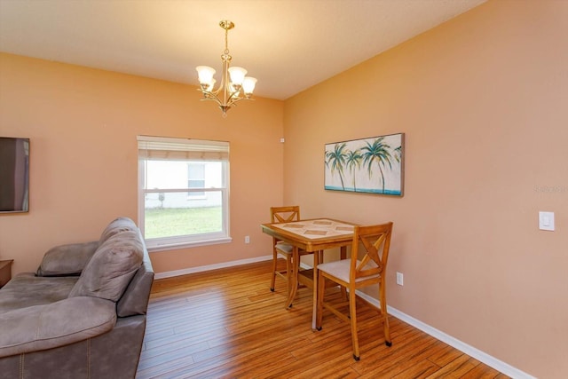 4642 Waterside Pointe Cir, Orlando, FL 32829 - dining area featuring wood finished floors, a chandelier, and baseboards