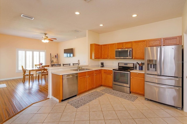 4642 Waterside Pointe Cir, Orlando, FL 32829 - kitchen featuring stainless steel appliances, a sink, light countertops, recessed lighting, and a peninsula