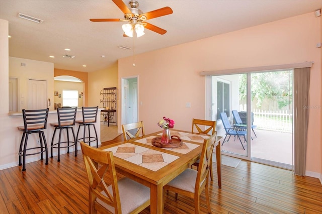 4642 Waterside Pointe Cir, Orlando, FL 32829 - dining room with wood finished floors, arched walkways, plenty of natural light, a ceiling fan, and recessed lighting