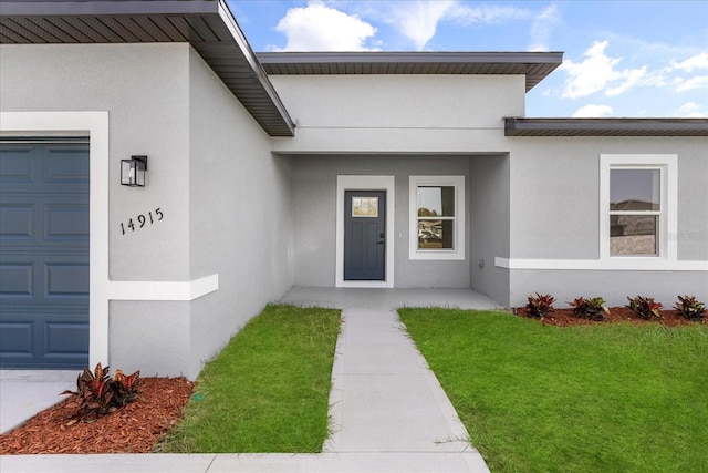 14915 SW 39th Cir, Ocala, FL 34473 - property entrance featuring stucco siding, a lawn, and a garage