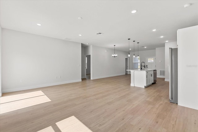 14915 SW 39th Cir, Ocala, FL 34473 - unfurnished living room featuring light wood-style floors, recessed lighting, a chandelier, baseboards, and a sink