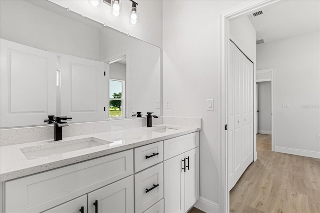14915 SW 39th Cir, Ocala, FL 34473 - bathroom featuring double vanity, wood finished floors, and baseboards