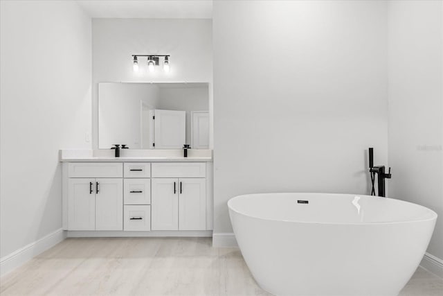 14915 SW 39th Cir, Ocala, FL 34473 - bathroom featuring double vanity, baseboards, and a freestanding tub