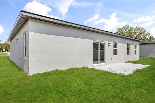 14915 SW 39th Cir, Ocala, FL 34473 - rear view of house featuring stucco siding, a patio, and a lawn