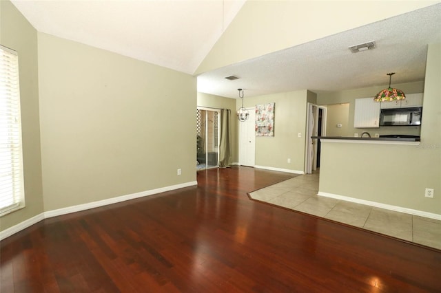 620 Glenwood Ct Unit 79, Altamonte Springs, FL 32714 - unfurnished living room with wood finished floors, lofted ceiling, and baseboards