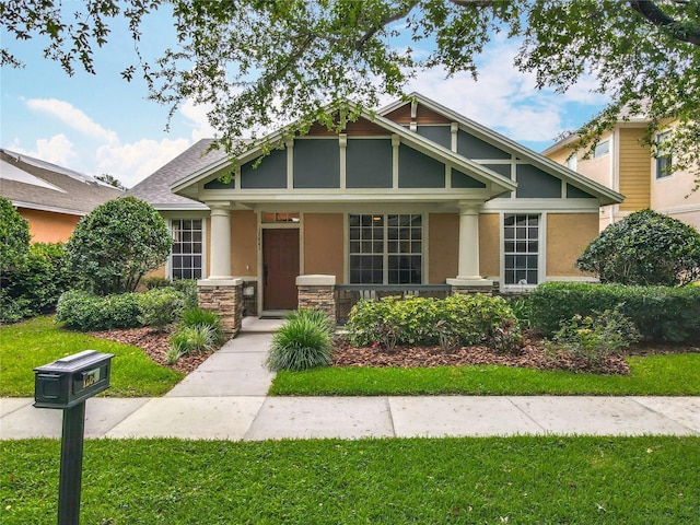 12641 Arley Dr, Windermere, FL 34786 - craftsman-style house featuring a porch, stucco siding, stone siding, and a front yard