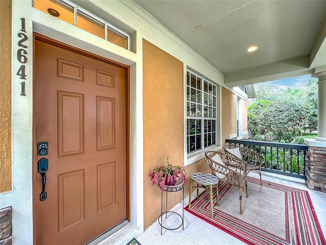 12641 Arley Dr, Windermere, FL 34786 - doorway to property with covered porch and stucco siding