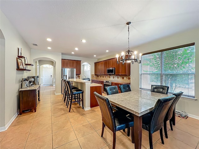 12641 Arley Dr, Windermere, FL 34786 - dining space featuring arched walkways, a chandelier, light tile patterned flooring, recessed lighting, and baseboards