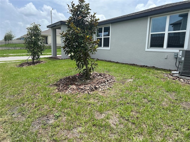 1345 Griffon Ave, Lake Alfred, FL 33850 - view of side of property with stucco siding, a yard, and cooling unit