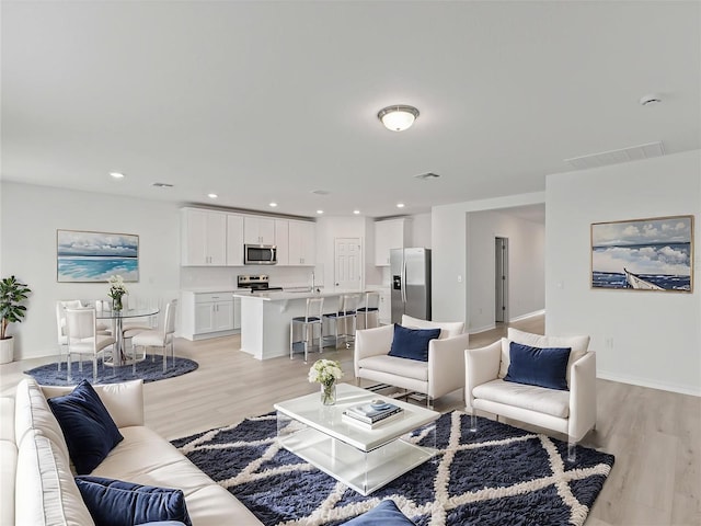 1345 Griffon Ave, Lake Alfred, FL 33850 - living room with light wood-style flooring, baseboards, and recessed lighting