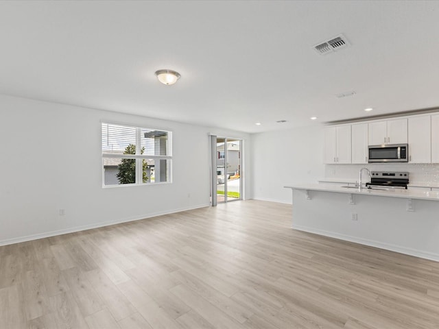 1345 Griffon Ave, Lake Alfred, FL 33850 - unfurnished living room with light wood-style flooring, a sink, recessed lighting, and baseboards