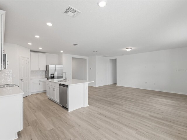 1345 Griffon Ave, Lake Alfred, FL 33850 - kitchen with a sink, stainless steel appliances, light wood-type flooring, open floor plan, and decorative backsplash