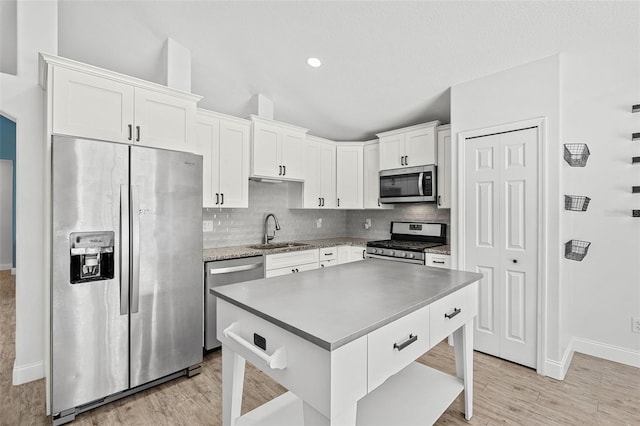 2913 Wilshire Rd, Clermont, FL 34714 - kitchen with stainless steel appliances, decorative backsplash, white cabinetry, and light wood finished floors