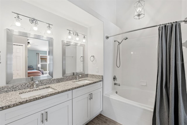 2913 Wilshire Rd, Clermont, FL 34714 - ensuite bathroom featuring shower / bath combo with shower curtain, double vanity, ceiling fan, and wood finished floors