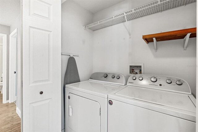 2913 Wilshire Rd, Clermont, FL 34714 - washroom with washer and clothes dryer and light wood-type flooring