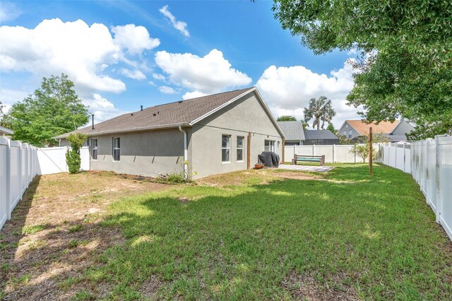 2913 Wilshire Rd, Clermont, FL 34714 - rear view of house with stucco siding and a fenced backyard
