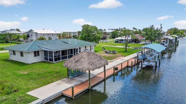 24277 Treasure Island Blvd, Punta Gorda, FL 33955 - rear view of house featuring boat lift, a sunroom, a water view, a metal roof, and a yard