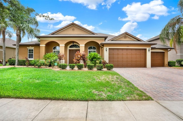 2313 Pesaro Cir, Ocoee, FL 34761 - ranch-style house with stucco siding, a garage, a front yard, and decorative driveway