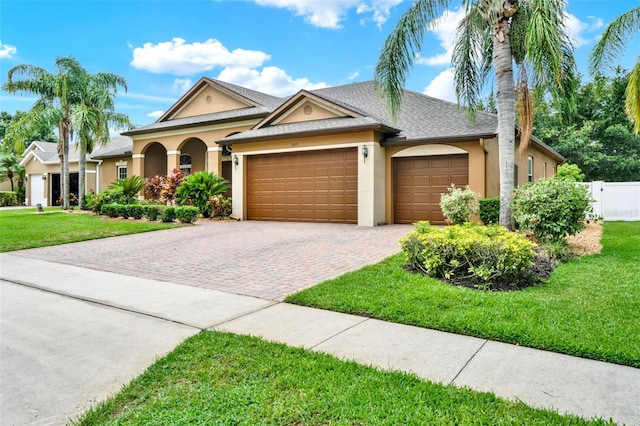 2313 Pesaro Cir, Ocoee, FL 34761 - ranch-style home with stucco siding, an attached garage, driveway, and a shingled roof