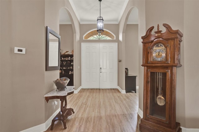 2313 Pesaro Cir, Ocoee, FL 34761 - foyer with arched walkways, wood finished floors, baseboards, and ornamental molding