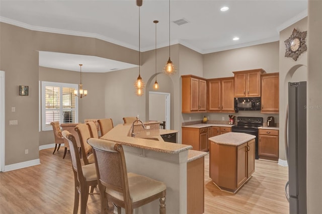 2313 Pesaro Cir, Ocoee, FL 34761 - kitchen featuring black microwave, an island with sink, a sink, freestanding refrigerator, and electric stove