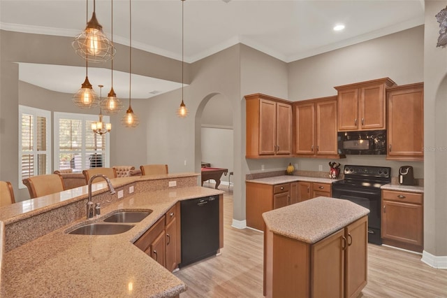 2313 Pesaro Cir, Ocoee, FL 34761 - kitchen featuring black appliances, a sink, a center island, light wood-type flooring, and arched walkways