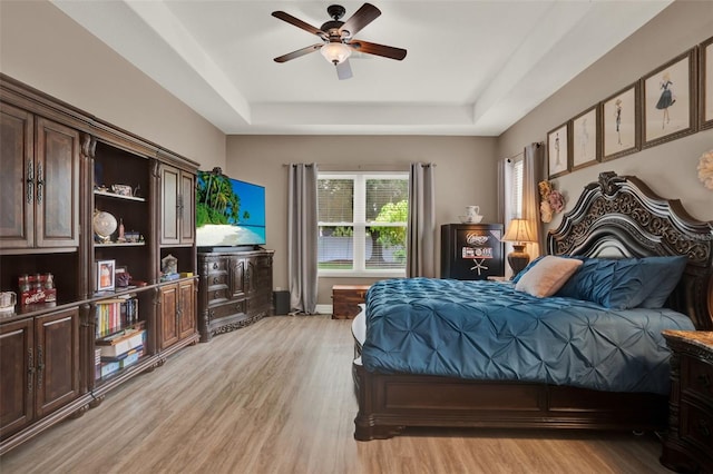 2313 Pesaro Cir, Ocoee, FL 34761 - bedroom featuring a tray ceiling, light wood-style flooring, a ceiling fan, and baseboards