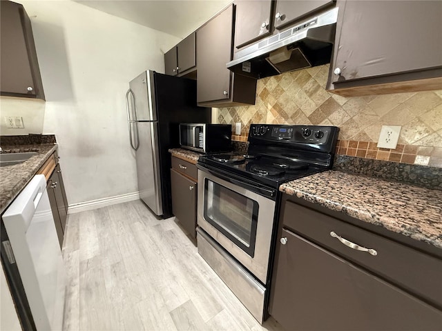 4756 Walden Cir Unit 21, Orlando, FL 32811 - kitchen with stainless steel appliances, under cabinet range hood, baseboards, backsplash, and light wood-style floors