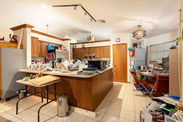 4933 Round Lake Rd, Apopka, FL 32712 - kitchen with black microwave, freestanding refrigerator, brown cabinetry, a peninsula, and stainless steel refrigerator with ice dispenser
