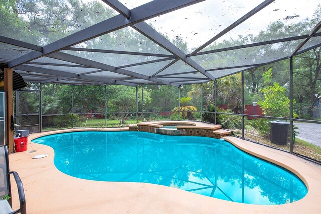 4933 Round Lake Rd, Apopka, FL 32712 - view of swimming pool featuring glass enclosure, a pool with connected hot tub, a patio area, and central air condition unit