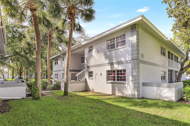 563 Midway Trak Unit K102, Ocala, FL 34472 - back of property with stucco siding and a lawn