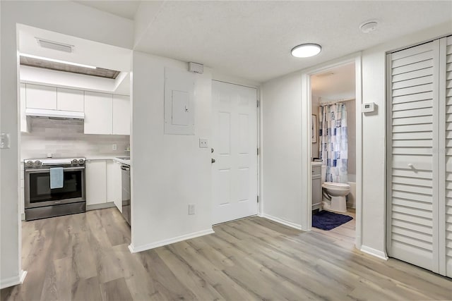 563 Midway Trak Unit K102, Ocala, FL 34472 - kitchen featuring appliances with stainless steel finishes, under cabinet range hood, white cabinets, and light wood finished floors