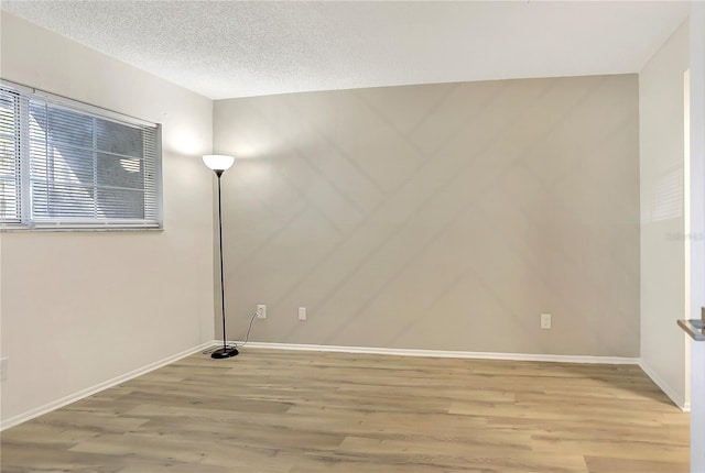 563 Midway Trak Unit K102, Ocala, FL 34472 - unfurnished room featuring wood finished floors, baseboards, and a textured ceiling