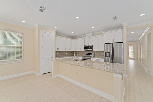 16357 SE 88th Ct, Summerfield, FL 34491 - kitchen with stainless steel appliances, a sink, white cabinetry, crown molding, and backsplash