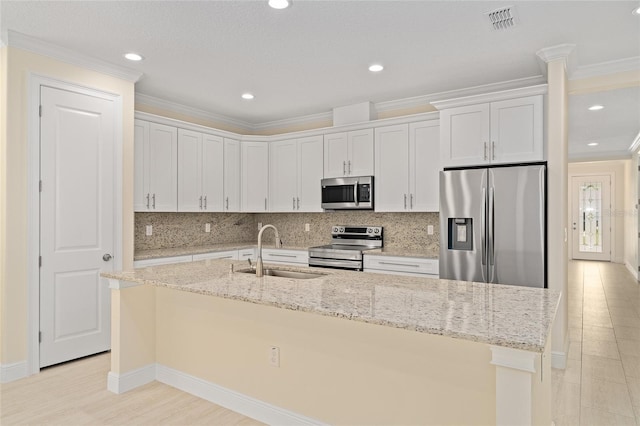 16357 SE 88th Ct, Summerfield, FL 34491 - kitchen featuring appliances with stainless steel finishes, a sink, white cabinetry, a center island with sink, and decorative backsplash