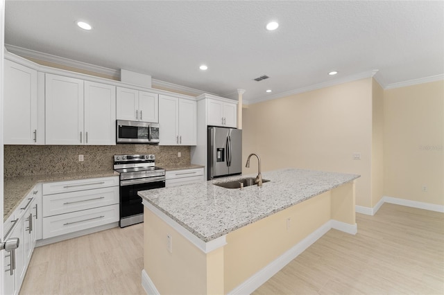 16357 SE 88th Ct, Summerfield, FL 34491 - kitchen featuring appliances with stainless steel finishes, a sink, crown molding, a center island with sink, and light wood finished floors
