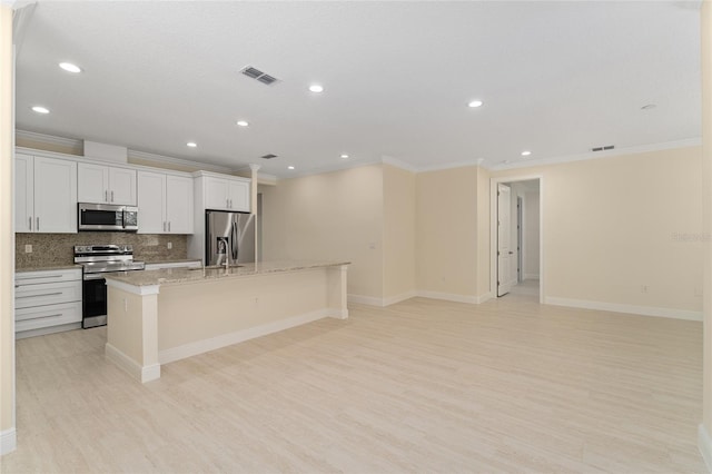 16357 SE 88th Ct, Summerfield, FL 34491 - kitchen with stainless steel appliances, ornamental molding, a center island with sink, light wood-style flooring, and decorative backsplash